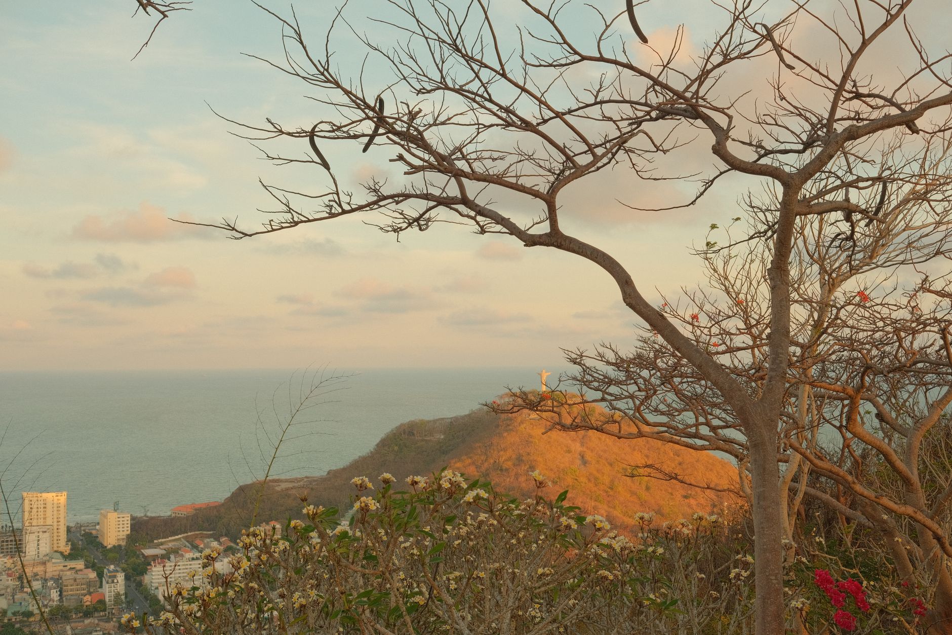 Vista panorámica de la bahía de San Juan del Sur con la estatua Cristo de la Misericordia al fondo, playas y ambiente costero al atardecer.